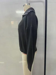 Side profile view of a vintage oversized dark gray knitted sweater with a polo collar