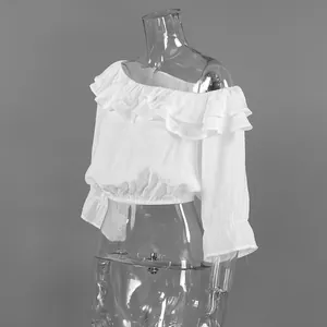 Détail d'un haut court blanc à volants et épaules dénudées sur un mannequin transparent