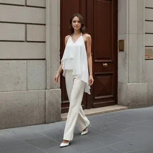 Elegant white chiffon halter top with asymmetrical hem shown on a model outdoors.