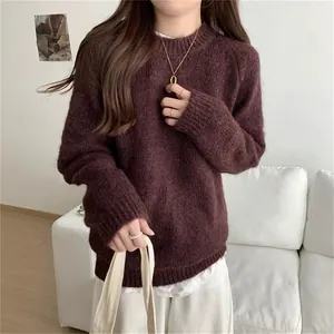 Vue détaillée d'un pull en tricot bordeaux ample pour femme dans un intérieur confortable