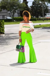Vista de detalle de los pantalones acampanados verde neón con dobladillo de volantes chic.