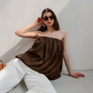 Détail rapproché d'un haut bustier plissé en satin marron chocolat porté par un mannequin