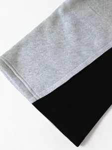 Detail der doppelt genähten Saum- und Color-Block-Stofftextur an weiten Jogginghosen.