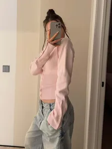Nahaufnahme der schmal geschnittenen rosa Strickjacke mit gerippten Details am Bund.