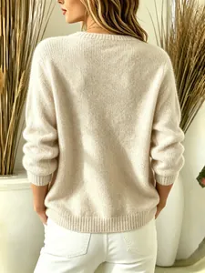 Back view of a soft cream long-sleeved knitted sweater featuring a ribbed hem and cuffs