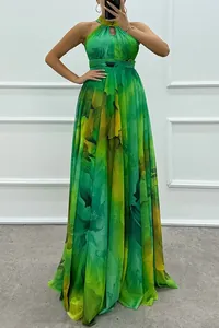 Detail view of a vibrant green floral print halter neck maxi dress with flowing skirt