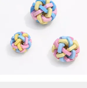 Detailed view of colorful TPR woven dog toy ball featuring an internal gold bell