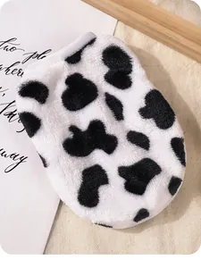 Primer plano de la suave tela de peluche con estampado de vaca para un chaleco de cachorro