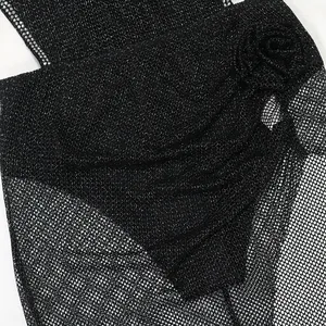 Vue détaillée montrant la texture brillante des strass et le tissu en maille de la robe body.