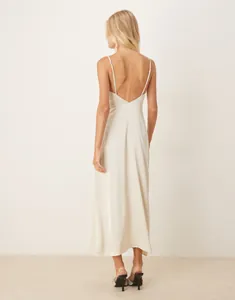 Detail view of the elegant open back and slim fit of a champagne satin slip dress
