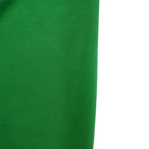Close-up detail of vibrant green textured fabric for elegant pencil dress