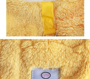 Close-up detail of yellow fleece pet dog clothes showing leash attachment and cute label.