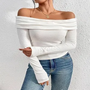 Vista dettagliata di un elegante top bianco da donna con spalle scoperte e maniche lunghe