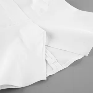 Detaillierte Makroansicht eines weißen Crop-Tops mit Seitenschlitz und Reißverschluss