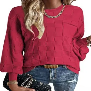 Detailed view of women's red long sleeve sweater with checkerboard textured knit and pocket