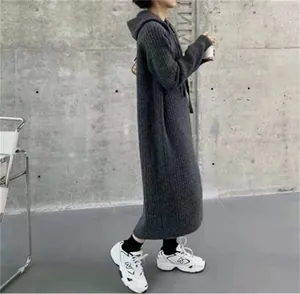 Full-body view of a cozy grey hooded knit sweater dress with a loose over-the-knee fit