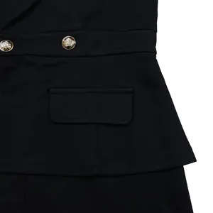 Detailed close-up showing golden embossed buttons and pocket on black fashion jumpsuit