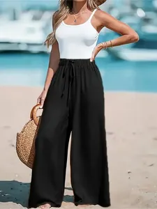 Macro view of black high-waisted wide-leg trousers for women styled on a beach