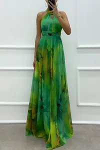 Detail of a green printed halter maxi dress showing the flowy fabric and elegant fit.