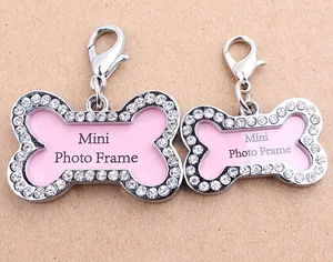 Close-up of pink rhinestone-encrusted bone pet ID tags with silver-tone lobster clasps