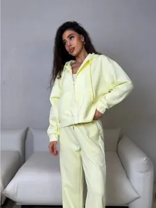 Detailed view of a lemon yellow zip-up tracksuit showing the oversized fit on model