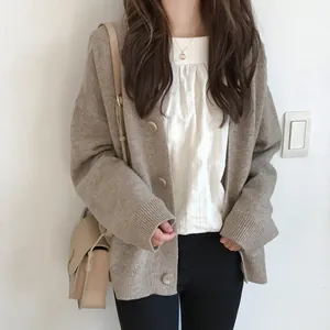 Close-up of a cozy beige knitted cardigan with oversized buttons worn by an Asian model.
