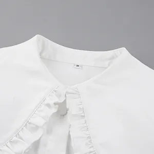 Close-up detail of white ruffled Peter Pan collar on a stylish French cotton blouse