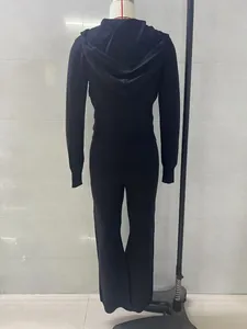 Vista posteriore di un completo nero a due pezzi in maglia con top con cappuccio.