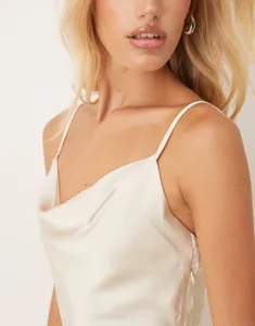 Detail showing the elegant cowl neck and luster of this champagne satin camisole dress