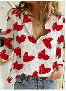 Close-up of women's white long sleeve shirt with vibrant red heart print details
