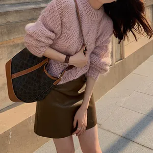 Close-up detailed view of the chunky pink cable knit texture on a cozy autumn sweater