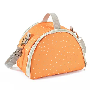 Close-up detail of a portable orange polka dot small animal carrier bag with strap