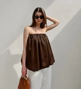 Haut péplum bustier en satin marron chic avec pantalon blanc pour l'été