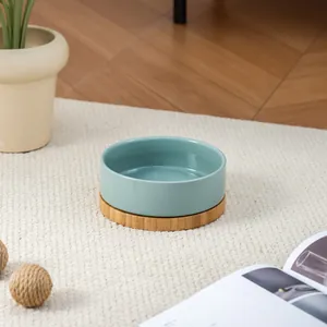 Ciotola minimalista in ceramica blu petrolio con supporto in bambù in ambiente domestico