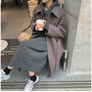 Details of a loose hooded gray knit dress styled with an oversized mauve wool coat.