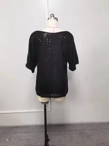 Vue arrière détaillée d'un haut noir ample à paillettes sur un mannequin d'exposition