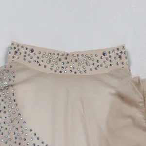 Detalle de diamantes de imitación brillantes en el cuello de un vestido beige