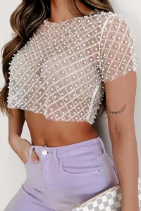 Detailed macro shot of sheer mesh crop top with pearl and sequin embellishments