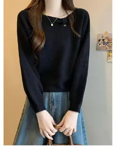 Close-up of black knit sweater with asymmetric knotted neckline and soft texture