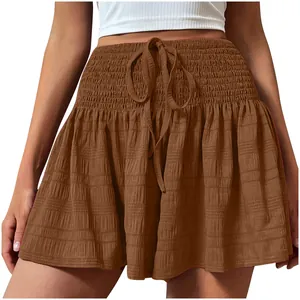 Detail view of stylish brown smocked waist shorts featuring drawstring and textured fabric.