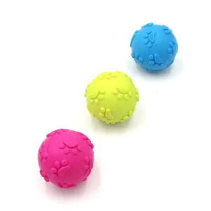 High-detail macro shot of three colorful TPR pet squeaky balls featuring raised paw patterns