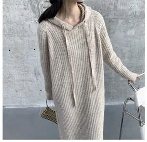 Detail view of oatmeal beige hooded knitted sweater dress featuring thick ribbed texture.