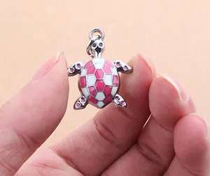 Close-up view of a pink and white checkered turtle-shaped pet ID tag charm for dogs