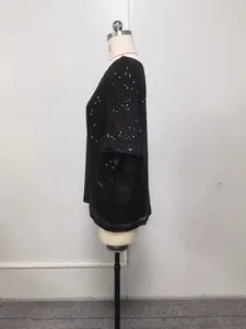 Vue latérale d'un haut noir à paillettes amples sur un mannequin d'exposition professionnel.