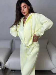 Model wearing pale yellow two-piece tracksuit with zip-up hoodie and sweatpants.