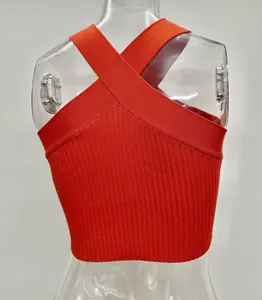 Back view detail of a vibrant orange ribbed knit crop top with cross-over halter straps.