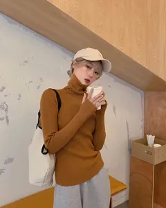 Chic mustard brown slim fit turtleneck ribbed sweater shown on model in cafe setting