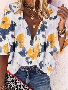 Macro detail of a women's floral print V-neck blouse featuring yellow and blue blossoms