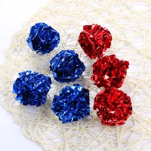 Bolas de papel crujiente azules y rojas para gatos sobre una alfombra de mimbre.