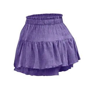 Dettaglio della vita a punto smock e degli strati a balze della gonna-pantalone viola.